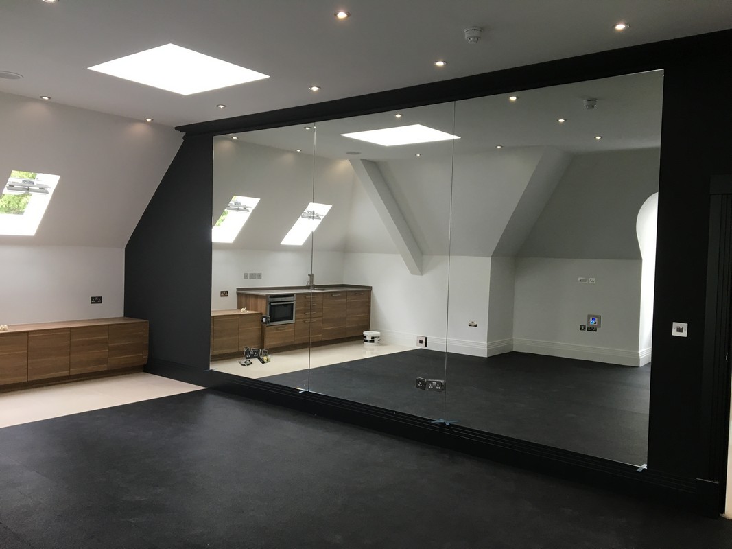 Frameless glass wall dividing loft conversion in Rickmansworth